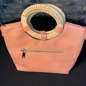 Coral color handbag with removable strap. Wicker wooden handles. Interior pouch.